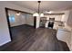 Open concept kitchen with stainless steel appliances, white cabinetry, and hardwood floors at 7817 Mattie Mccoy Ln, Winston, GA 30187