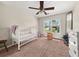 Bedroom with ceiling fan, crib, and large window providing plenty of natural light at 1165 Evergreen Oak Way, Dacula, GA 30019