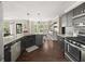 Modern kitchen with stainless steel appliances, dark cabinets, granite countertops, and hardwood floors at 1165 Evergreen Oak Way, Dacula, GA 30019