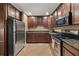 Galley kitchen with stainless steel appliances, granite countertops, and tile flooring at 1165 Evergreen Oak Way, Dacula, GA 30019