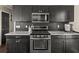 Updated kitchen with stainless steel appliances, granite countertops and dark cabinetry at 1165 Evergreen Oak Way, Dacula, GA 30019