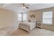 Spacious main bedroom with a tray ceiling, ceiling fan, carpet and three windows at 1691 Scenic Pines Dr, Lawrenceville, GA 30044