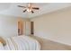 Spacious main bedroom with a tray ceiling, ceiling fan, carpet and access to the bathroom at 1691 Scenic Pines Dr, Lawrenceville, GA 30044