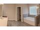Bathroom featuring tile floors, a tub, and a window at 4685 Columbia St, Cumming, GA 30040