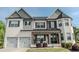 Charming two-story home with a stone porch, white brick, two-car garage, and manicured landscaping at 4685 Columbia St, Cumming, GA 30040