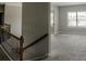 Upstairs hallway with carpet floors, wooden banister, and natural light at 4685 Columbia St, Cumming, GA 30040