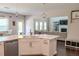 This bright kitchen includes an island with seating, stainless appliances and an open view to the living room at 4685 Columbia St, Cumming, GA 30040