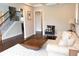 Bright living room with a tufted sofa, plush rug, modern decor, and a staircase in the background at 4685 Columbia St, Cumming, GA 30040