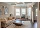 Inviting living room boasts a tufted sofa, plush rug, coffered ceilings, and abundant natural light at 4685 Columbia St, Cumming, GA 30040