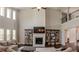 Spacious living room featuring a fireplace, large windows, hardwood floors, tall ceilings, and modern shelving at 4685 Columbia St, Cumming, GA 30040