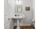 Stylish half-bathroom with pedestal sink, modern fixtures, and wood-look flooring at 965 River Overlook Ct, Sandy Springs, GA 30328