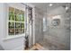 Modern bathroom features a glass enclosed shower with stone floor and niche, and a lovely outdoor view at 965 River Overlook Ct, Sandy Springs, GA 30328