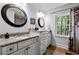Bright bathroom with granite counters, stylish mirrors, white cabinets, and a window view of the outdoor scenery at 965 River Overlook Ct, Sandy Springs, GA 30328