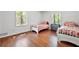 Bright bedroom with hardwood floors, twin beds with red and white linens, and a large window at 965 River Overlook Ct, Sandy Springs, GA 30328