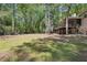 Large, green backyard showing exterior of home with brick facade, wood deck and screened-in porch at 1496 Country Squire Dr, Decatur, GA 30033