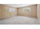 Bright bedroom with two windows, wood-paneled walls, and neutral carpeting at 1496 Country Squire Dr, Decatur, GA 30033