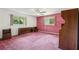 Vintage bedroom featuring pink plaid wallpaper, matching pink carpet, and a ceiling fan at 1496 Country Squire Dr, Decatur, GA 30033