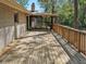 Spacious wooden deck area, with wood railing, leading to a screened-in porch and the home's brick facade at 1496 Country Squire Dr, Decatur, GA 30033