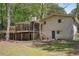 Rear exterior view of home showing brick facade, wooden deck, patio and screened porch at 1496 Country Squire Dr, Decatur, GA 30033