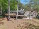 Back of home view showing deck, screened-in porch and large backyard amid tall trees at 1496 Country Squire Dr, Decatur, GA 30033