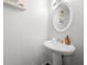Bright half bathroom featuring a pedestal sink, decorative mirror, and white paint at 625 Outlook Way, Atlanta, GA 30349