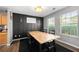 Cozy dining area features a long wooden table, with black accent wall and natural light at 625 Outlook Way, Atlanta, GA 30349