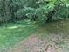 A view of the grassy backyard and surrounding trees at 861 Creek Nw Trl, Kennesaw, GA 30144