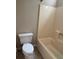 Modest bathroom featuring a standard toilet and a combined tub and shower unit with a light beige surround at 861 Creek Nw Trl, Kennesaw, GA 30144