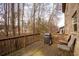 A back deck with seating and grill overlooks a wooded lot with privacy fence at 8664 Spivey Village Trl, Jonesboro, GA 30236