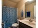 Bright bathroom with a blue patterned shower curtain, and a single sink vanity at 8664 Spivey Village Trl, Jonesboro, GA 30236