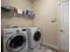 Functional laundry room with modern washer and dryer units, shelving, and ample storage at 8664 Spivey Village Trl, Jonesboro, GA 30236