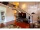 Inviting living room featuring hardwood floors, a stone-accented staircase, and an entertainment center at 8664 Spivey Village Trl, Jonesboro, GA 30236