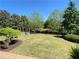 Spacious backyard featuring a well-maintained lawn and mature trees, ideal for outdoor activities at 311 Carmichael Cir, Canton, GA 30115