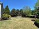 Lush backyard with mature trees, manicured lawn, and garden features at 311 Carmichael Cir, Canton, GA 30115
