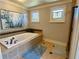 Well lit bathroom featuring soaking tub and stained glass windows at 311 Carmichael Cir, Canton, GA 30115