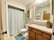 Cozy bathroom featuring a toilet, sink, shower, and wall mounted shelving at 311 Carmichael Cir, Canton, GA 30115