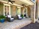 Inviting brick front porch with comfortable seating, ceiling fans, and decorative accents at 311 Carmichael Cir, Canton, GA 30115