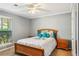 This cozy bedroom features a plush bed, blue accent pillows, and natural light from the window at 4425 Reef Rd, Marietta, GA 30066