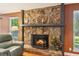 Close-up of stone fireplace with decorative candles and mantle with burning fire at 4425 Reef Rd, Marietta, GA 30066