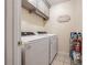 Laundry room with washer, dryer, overhead cabinets, tile flooring and a decorative sign at 4510 Flowering Br, Powder Springs, GA 30127