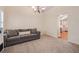Open-concept living room with plush carpeting, modern chandelier, and doorway to adjacent kitchen at 4510 Flowering Br, Powder Springs, GA 30127