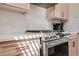 Close-up of a stainless steel gas range and white tile backsplash with bright sunlight at 4510 Flowering Br, Powder Springs, GA 30127