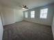 Large bedroom featuring neutral carpet, three windows providing plenty of natural light, and ample space at 5022 Buice Crest Court, Buford, GA 30518