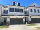 Charming townhome featuring a brick and white exterior with a two-car garage and inviting front entrance at 5022 Buice Crest Court, Buford, GA 30518