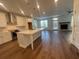 Open-concept kitchen with white cabinets, a large island, and hardwood floors at 5022 Buice Crest Court, Buford, GA 30518