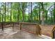 This covered back porch has wood railing, brick trim, and steps down to the large backyard at 800 Kiowa Ne Dr, Marietta, GA 30060