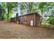 Back of brick home with deck and manicured yard, showing brick chimney and basement door at 800 Kiowa Ne Dr, Marietta, GA 30060