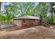 Back of red brick home with deck and driveway. A fence partially surrounds the property at 800 Kiowa Ne Dr, Marietta, GA 30060