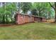 Charming single-story brick home with a covered front porch, well-maintained lawn and mature trees at 800 Kiowa Ne Dr, Marietta, GA 30060