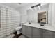 Bathroom with gray cabinets, double sinks, a large mirror, and attractive lighting at 10900 Wittenridge Dr # I4, Alpharetta, GA 30022